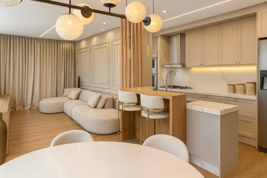 Sala de estar e jantar integradas à cozinha, com divisória de ripas de madeira.