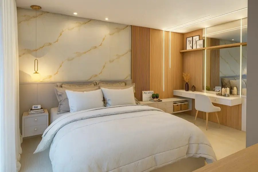 Cama de casal com cabeceira em mármore dourado, luminária pendente e bancada de apoio em madeira.